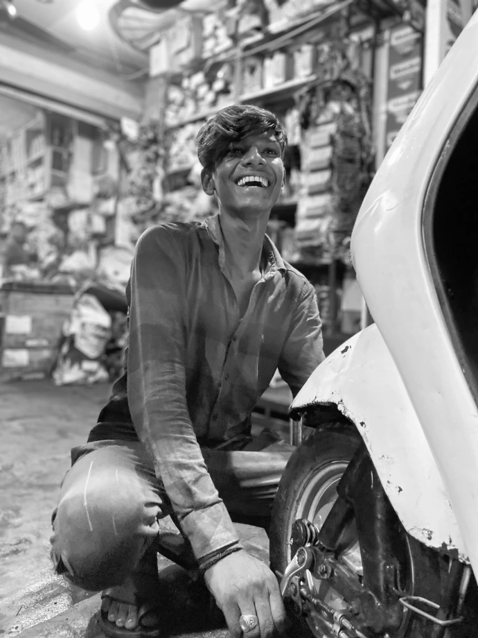 a man smiling and leaning on a car